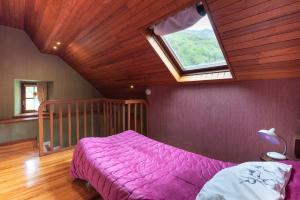 a bedroom with a purple bed and a window at Cottage au Calme in Gèdre
