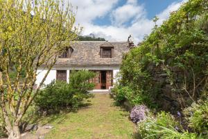 a white house with a garden in front of it at Cottage au Calme in Gèdre