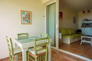 a living room with a table and chairs and a couch at Restanques de Saint Tropez - arums in Grimaud