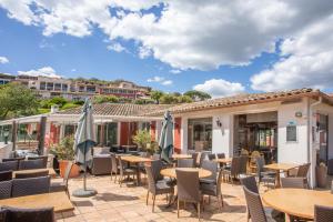 a patio with tables and chairs and umbrellas at Restanques de Saint Tropez - arums in Grimaud