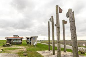 a group of wooden poles in front of a building at Bi uns to hus - Obendsünn in Nordstrand