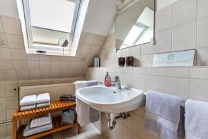 a bathroom with a sink and a mirror and towels at Bi uns to hus - Obendsünn in Nordstrand +11 photos