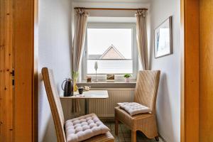 a room with a table and chairs and a window at Bi uns to hus - Obendsünn in Nordstrand