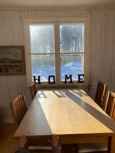 a wooden table in a room with a window at Mysig Stuga in Sveg