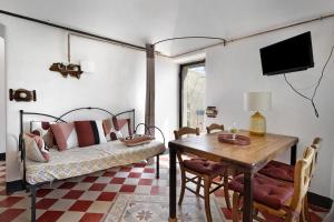 a room with a table and a bed and a table and chairs at Agriturismo Bricco in Finale Ligure