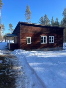a log cabin in the snow with a snow path at Mysig Stuga in Sveg