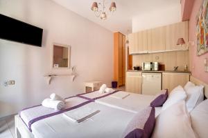 a bedroom with a large bed and a kitchen at Nontas Home 26 in Kalamitsi
