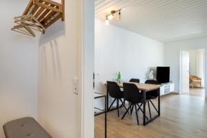a dining room and living room with a table and chairs at Bodenseenest in Meckenbeuren
