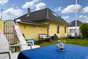 a table with a blue table cloth on a yard with a house at Ferienwohnung Küstenstübchen Gruse in Bartenshagen-Parkentin