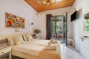 a bedroom with a large bed and a tv at Nontas Homes 36 in Kalamitsi