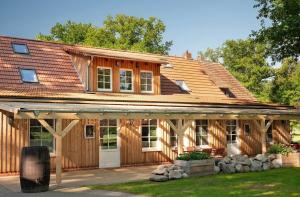 a wooden house with a gambrel roof at Schwalbenloft in Wagenfeld