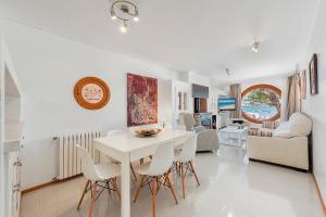 a dining room and living room with a white table and chairs at Ull de Bou in Port de Pollensa