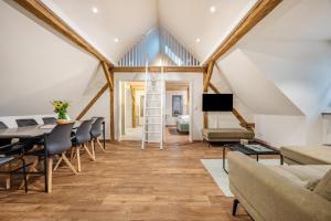 a living room with a table and chairs and a ladder at Schwalbenloft in Wagenfeld