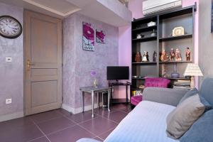 a living room with a couch and a clock on a wall at Les Oliviers in Cassis