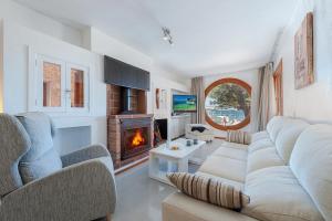 a living room with a couch and a fireplace at Ull de Bou in Port de Pollensa