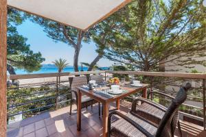 a table and chairs on a balcony with a view of the ocean at Ull de Bou in Port de Pollensa
