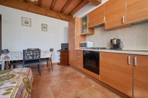 a kitchen with wooden cabinets and a table in it at Podere Chinco - Gavorrano in Gavorrano