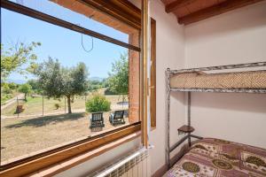 a bedroom with a window with a bed and a view at Podere Chinco - Gavorrano in Gavorrano +16 photos