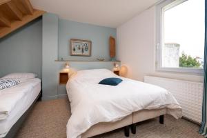 a bedroom with two beds and a window at Maison Ty Sioul - proche plage in Quiberon