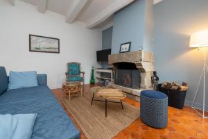 a living room with a blue couch and a fireplace at Maison Ty Sioul - proche plage in Quiberon