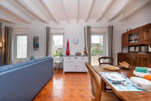 a living room with a table and a blue couch at Maison Ty Sioul - proche plage in Quiberon