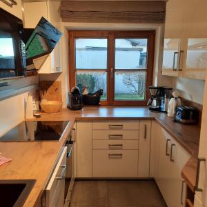 a kitchen with white cabinets and a window at Chaletwohnung Alpenglück in Burgberg