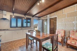 a kitchen and dining room with a wooden table at Casa Eyden Sunset View in Arona