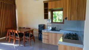 a kitchen with a table and chairs and a sink at Rumah Gajah by Kubukubali in Pemuteran