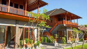 a house with a balcony on the side of it at Rumah Gajah by Kubukubali in Pemuteran