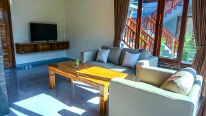 a living room with a couch and a table at Rumah Gajah by Kubukubali in Pemuteran
