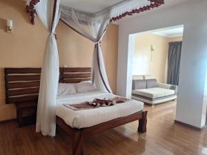 a bedroom with a bed with a canopy at Fairways Hotel in Narok