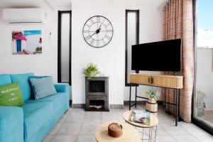 a living room with a blue couch and a tv at Maravilha da Costa in Ponta do Pargo