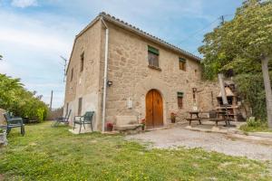 an old stone building with a wooden door at Cal Viudet in Caserras