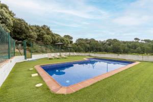 a swimming pool in the middle of a grassy yard at Cal Viudet in Caserras