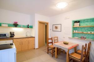 a kitchen and dining room with a table and chairs at Peter Paul Gartenapt. Palme in Appiano Sulla Strada Del Vino