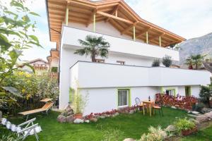 a white house with a wooden roof at Peter Paul Gartenapt. Palme in Appiano Sulla Strada Del Vino