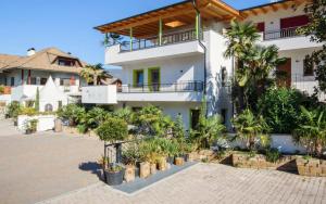 a large white building with a lot of plants at Peter Paul Gartenapt. Palme in Appiano Sulla Strada Del Vino