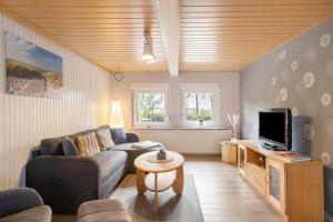 a living room with a couch and a tv at Urlaub an der Elbmündung in Neuenkirchen