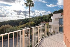 a balcony with a palm tree and a building at Saint Claude in Marina di Andora