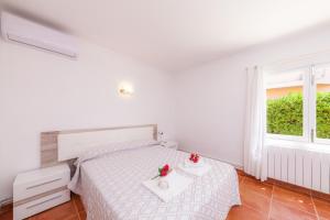a white bedroom with a bed and a window at Bona Mar in Cala Ratjada +35 photos