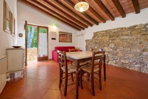 a dining room with a table and a stone wall at Poggio Diavolino - Suvereto in Suvereto