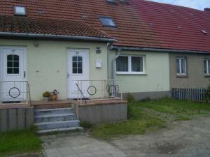 a house with a porch and stairs in front of it at Ferienwohnung Kelpin in Möllenbeck