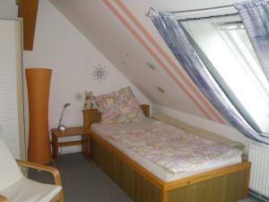 a small bedroom with a bed and two windows at Ferienwohnung Kelpin in Möllenbeck