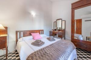 a bedroom with a bed with towels and a mirror at Can Joi in Sóller