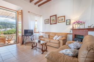 a living room with a couch and a fireplace at Can Joi in Sóller