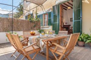 a wooden table and chairs on a patio at Can Joi in Sóller