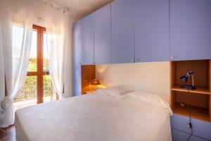 a bedroom with a white bed and a window at Casa Carlotta in Costa Paradiso in Costa Paradiso