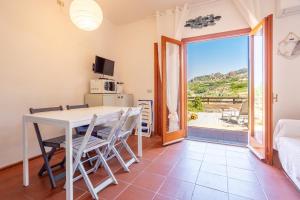 a living room with a table and chairs and a balcony at Casa Carlotta in Costa Paradiso in Costa Paradiso +19 photos