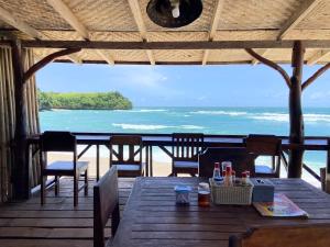 a table with chairs and a view of the ocean at Santai Surf Lodge-Balangan in Uluwatu +9 photos