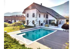 a house with a swimming pool in front of it at Le Balcon des Bauges in La Motte-Servolex